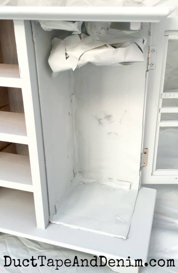 Covered mirror and felt before spraying painting thrift store jewelry cabinet makeover | DuctTapeandDenim.com