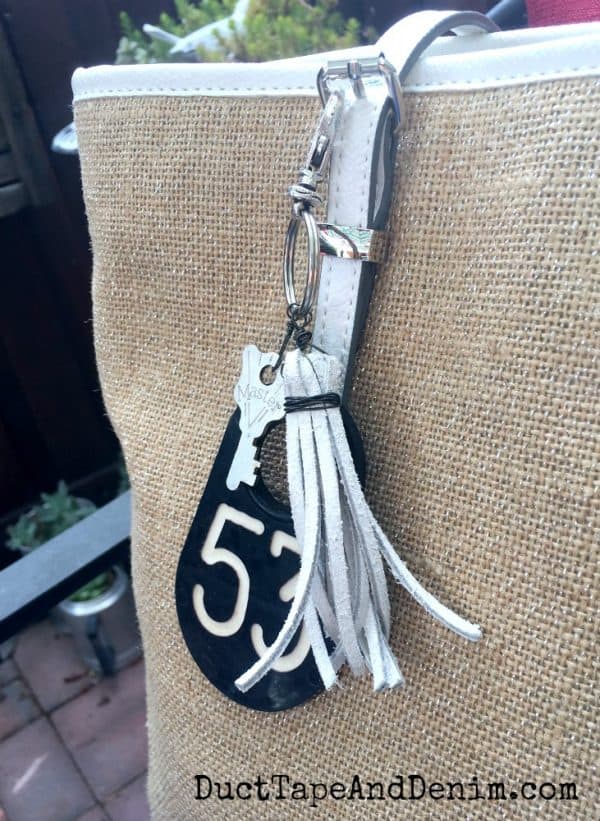 DIY purse charm with old cow ear tag, leather tassel and key | DuctTapeAndDenim.com